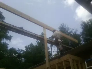Carpenter setting a ridge beam over a new addition frame — Ice Dam Removal by Roofing Brothers in Glenpool