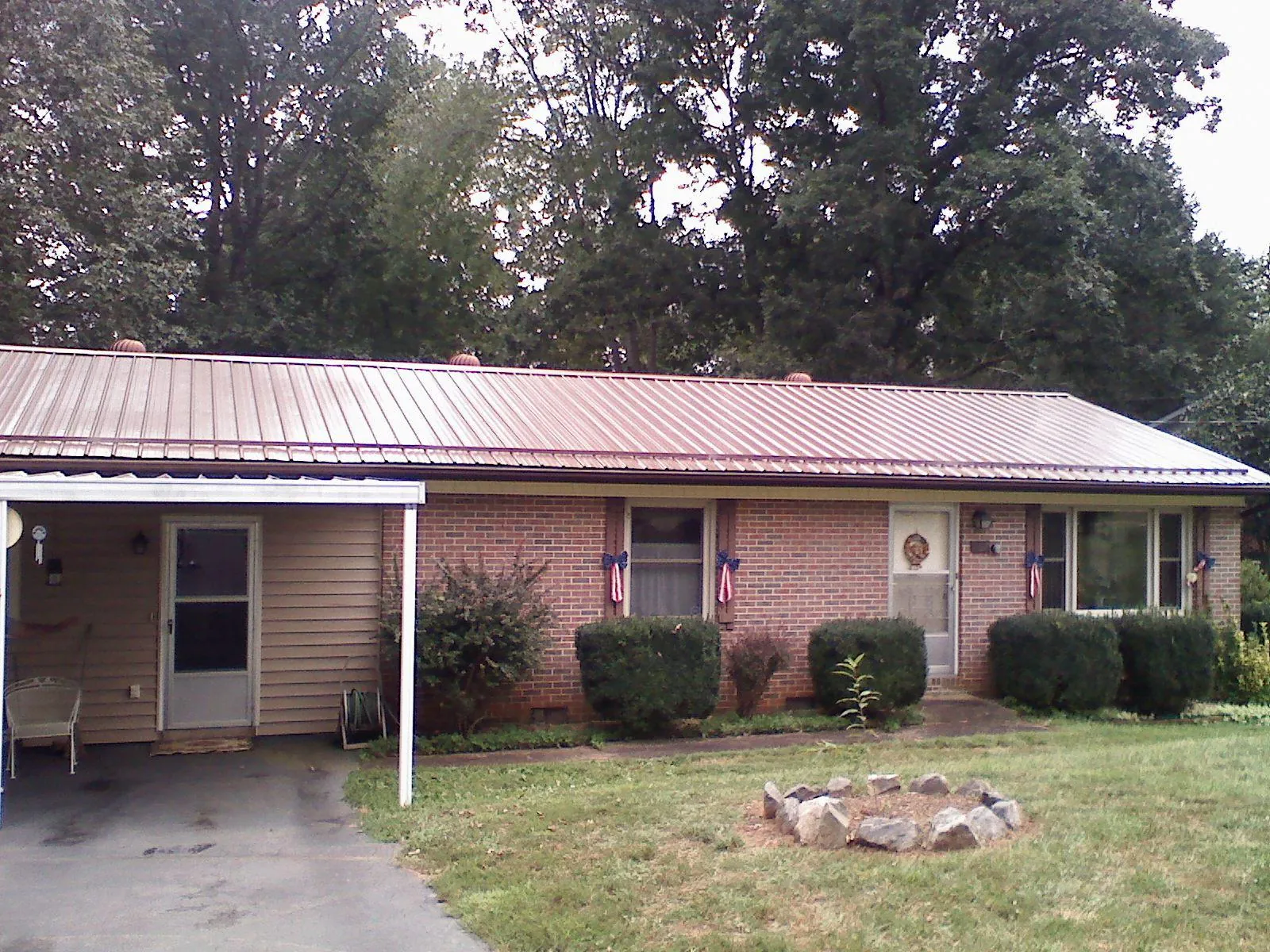 Bronze metal roof and carport on a brick ranch home — Roof Repair work by our crew in Glenpool
